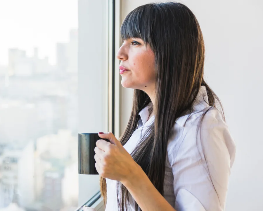 Mujer pensativa mirando por la ventana